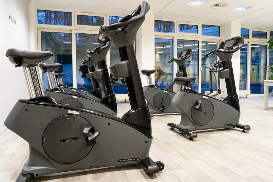 Moderne Ergometergeräte im Ergometerraum mit vielen Fenstern Moderne Ergometergeräte im Ergometerraum mit vielen Fenstern